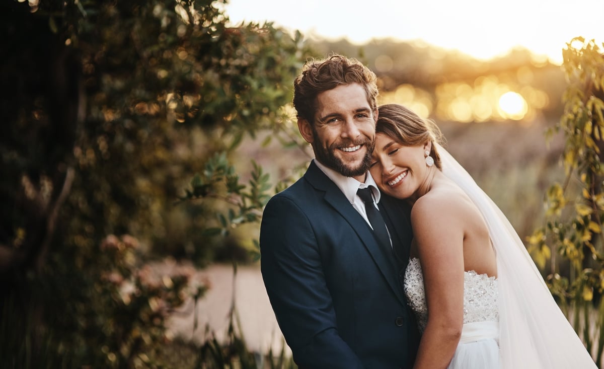 Happy young couple embracing on their wedding day at golden hour